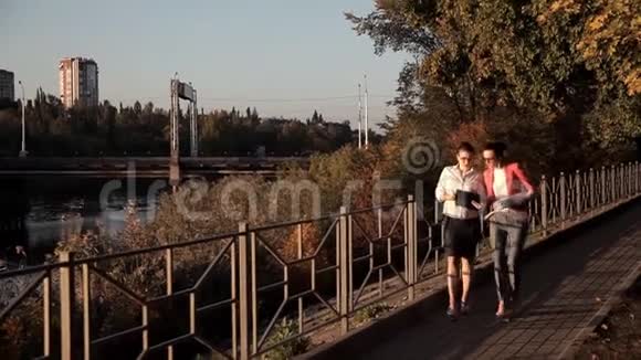 年轻的女建筑师走在城市的河边回顾他们的项目视频的预览图