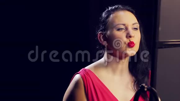 年轻的女人穿着红色的裙子涂着红色的口红微笑着特写视频的预览图