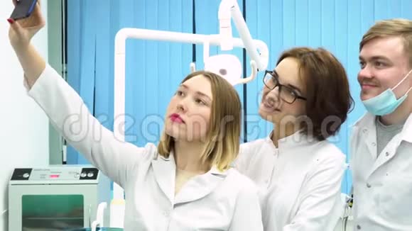 微笑男女医生统一制作自拍年轻的牙医在牙科诊所的柜子里拍照视频的预览图