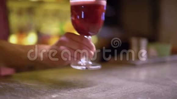男人的手把装有粉红色鸡尾酒和桑椹的玻璃杯放在桌子上视频的预览图