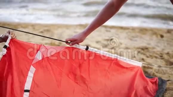年轻的夫妇或朋友在海滨铺了一个红色的帐篷积极的休息旅游休闲理念视频的预览图
