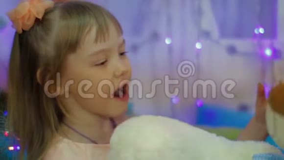 快乐的女孩拥抱泰迪熊儿童新年礼物视频的预览图