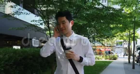 男子使用手机沿街行走4k视频的预览图
