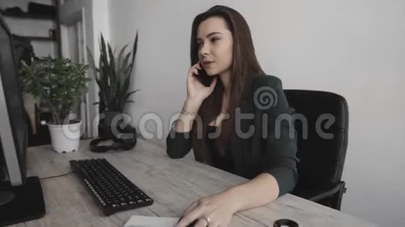 白色办公室中年轻商务女性对着电脑屏幕说话的肖像女企业家打电话视频的预览图