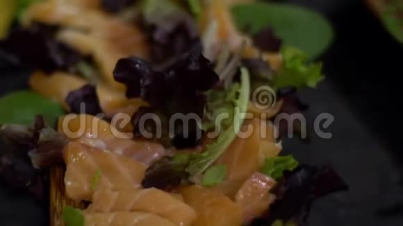 慢动作的美味三文鱼沙咪咪与绿色蔬菜叶视频的预览图