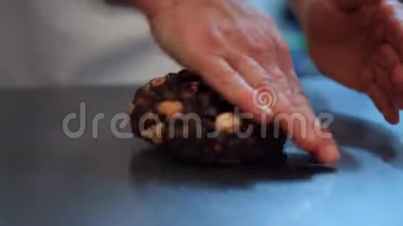 一位糕点厨师正在用巧克力蜂蜜榛子和葡萄干18FDV揉制糕点视频的预览图