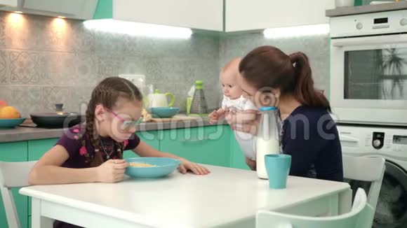 早上的家庭早餐厨房餐桌上吃玉米片和牛奶的女孩视频的预览图