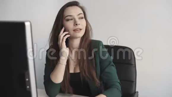 白色办公室中年轻商务女性对着电脑屏幕说话的肖像女企业家打电话视频的预览图