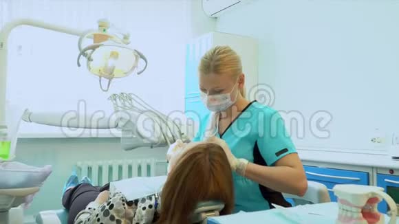 使用消毒设备进行手术的牙医牙医的肖像牙科椅上的病人牙科视频的预览图