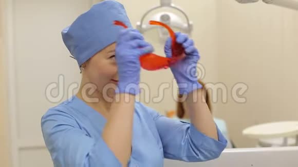 女医生在与一位客户合作之前在她的眼睛上戴上橙色的护目镜视频的预览图