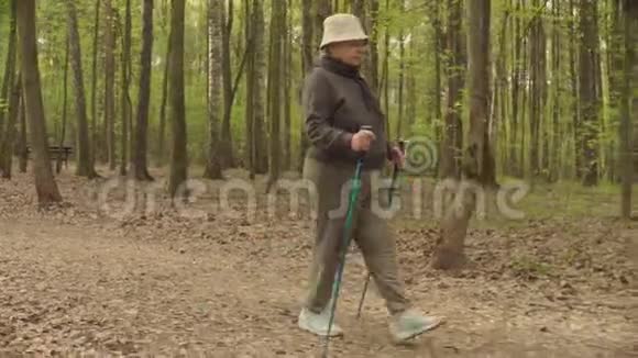 带着登山杆行走的老年活跃妇女视频的预览图