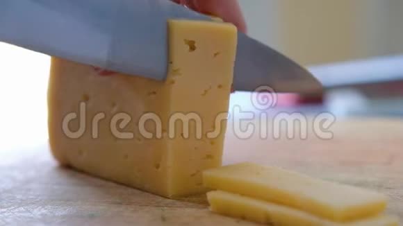 一位中年厨师在木板上用刀切奶酪把它关上视频的预览图