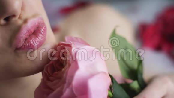 一个女人躺在浴室里手里拿着一朵粉红色的玫瑰视频的预览图