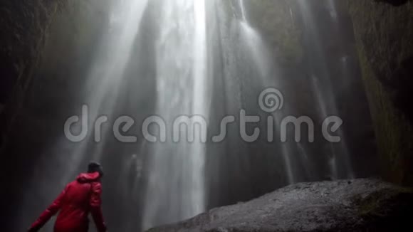 年轻的幸福夫妇站在冰岛美丽的瀑布下举起双手感受自由和快乐视频的预览图