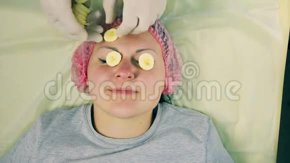 时光飞逝化妆师的男人的手在女人的脸上放了一个香蕉上的面具视频的预览图