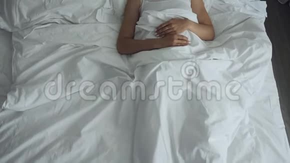 女人醒来在舒适舒适的床上伸展和起床视频的预览图
