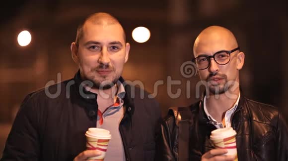 两个秃头在晚上为照相机摆姿势视频的预览图