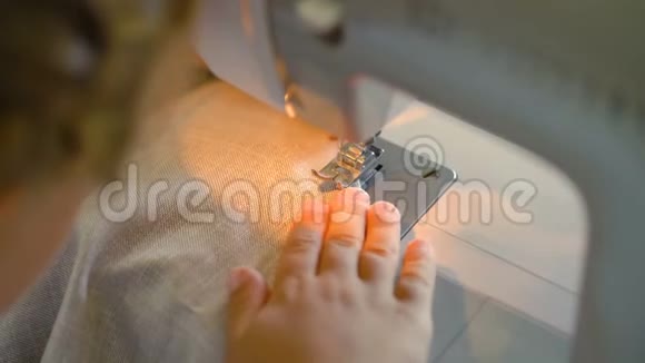 七岁的女孩在家里用缝纫机缝衣服视频的预览图