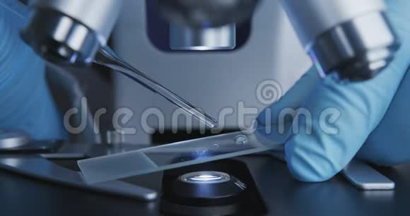 技师把吸管滴在玻璃玻片上以便在显微镜下进一步检查视频的预览图