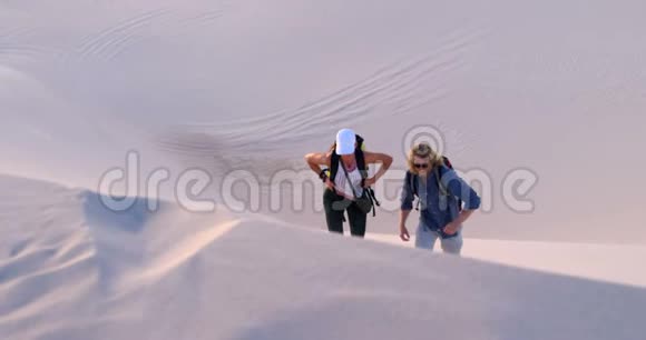 双肩背包爬上沙丘4k视频的预览图
