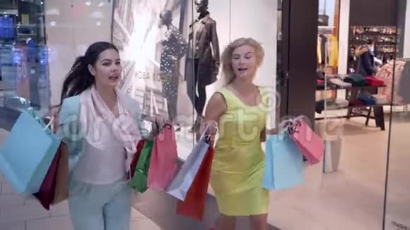 购物狂美丽的女性朋友在黑色星期五从购物中心跑到商店短信出现在视频的预览图