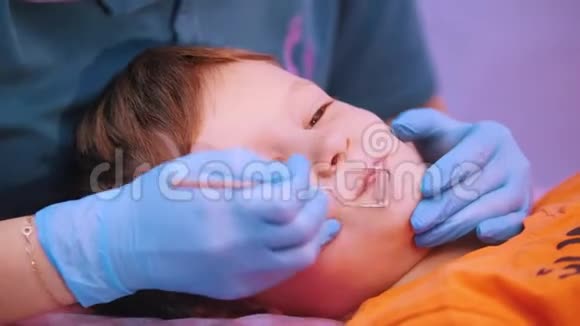 医学诊所患有脑瘫疾病的婴儿言语治疗按摩一个女人用特殊的仪器工作视频的预览图