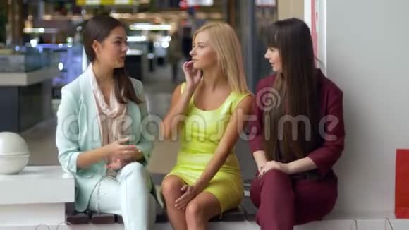 购物中心的女朋友穿着五颜六色的衣服看着相机微笑着拿着纸袋购物视频的预览图