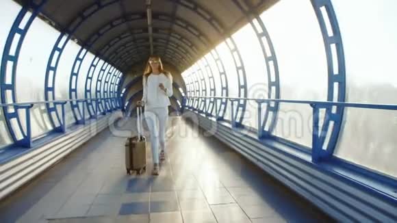 stadicam镜头生命在运动时尚女性带着旅行袋在航站楼之间的阳光下移动视频的预览图