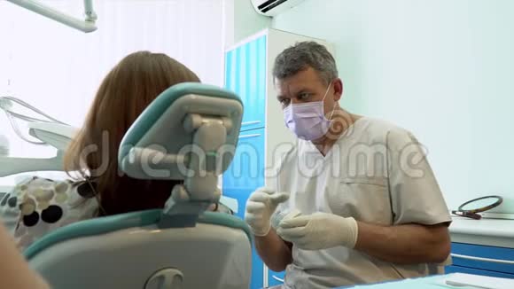 使用消毒设备进行手术的牙医牙医的肖像牙科椅上的病人牙科视频的预览图