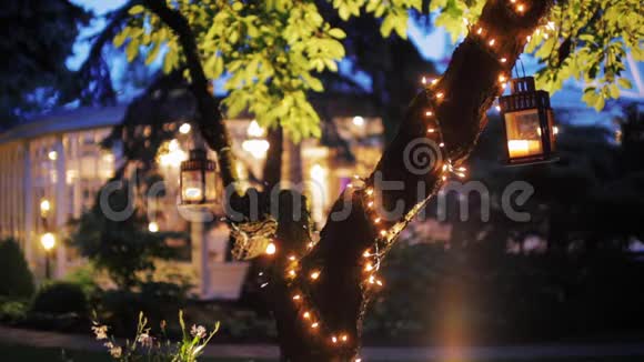 餐厅附近有加兰和灯笼的树的神奇背景夜视频视频的预览图