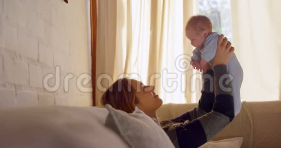 妈妈抱着她的婴儿脸在客厅4k视频的预览图