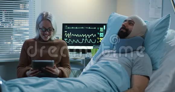 女人用平板电脑展示受伤男人视频的预览图