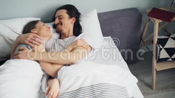 丈夫和妻子穿着睡衣在家里的卧室里拥抱着视频的预览图