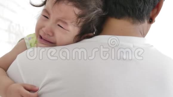 年轻的父亲在家里的卧室里安慰一个哭泣的小婴儿视频的预览图