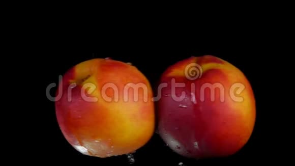 两个甜美的桃子在黑色的背景下相撞视频的预览图