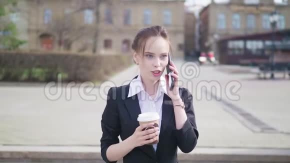 城市女商人用智能手机和外卖咖啡视频的预览图
