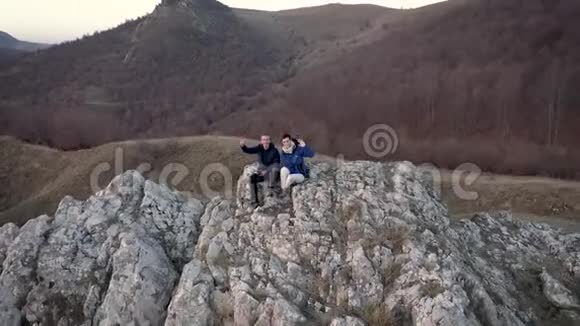 远足夫妇在高峰上放松空中4k无人机电影视频的预览图
