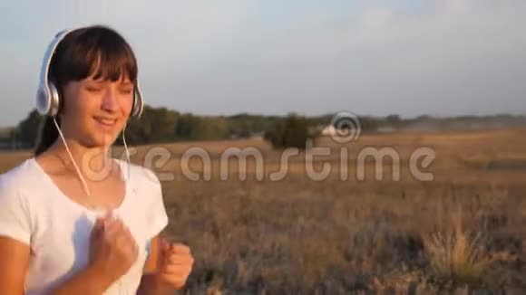 快乐女孩在耳机里练习慢跑视频的预览图