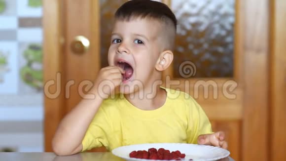 孩子坐在桌边在厨房吃树莓视频的预览图
