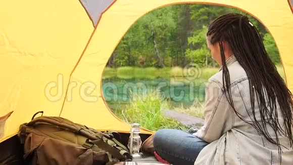 女人在帐篷里放松徒步旅行夏季野外旅行视频的预览图