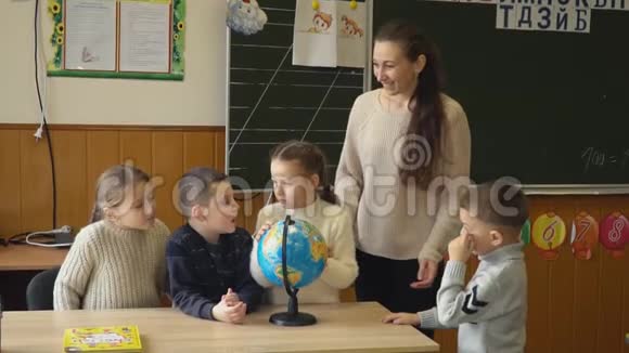 老师教孩子们使用地球仪视频的预览图