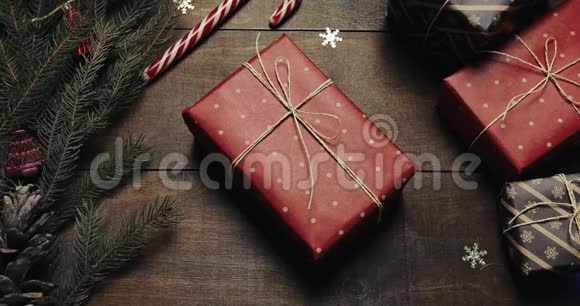 上景木制棕色桌子上面装饰着圣诞用品和花环礼物在桌子上男人手带走视频的预览图