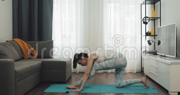 年轻女子在家锻炼健身女孩在垫子上做瑜伽练习健康和运动的生活方式视频的预览图
