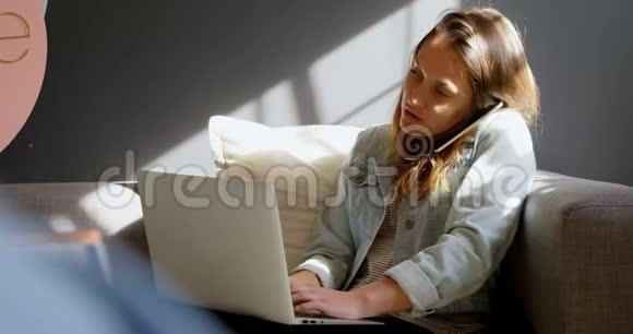 女性珠宝设计师在使用笔记本电脑4k时使用手机视频的预览图