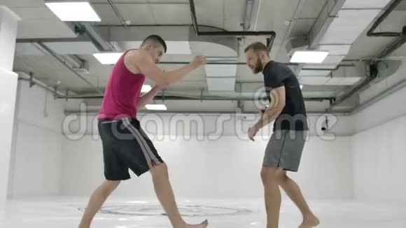 镜头跟在摔跤手后面MMA战斗机在训练轨道上设计摔跤装备捕获视频的预览图
