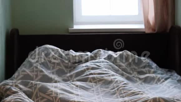 一个年轻的女孩躺在床上清晨醒来啜饮着双手视频的预览图