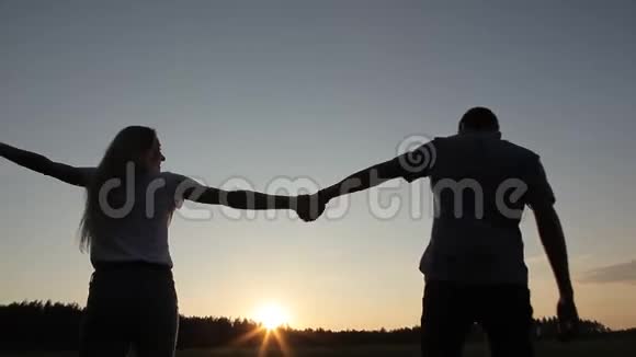 日落时分在田野里相爱的男人和女孩视频的预览图