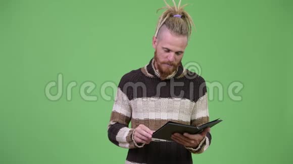 穿暖和的衣服时长着大胡子的英俊男子带着可怕的家伙看书视频的预览图