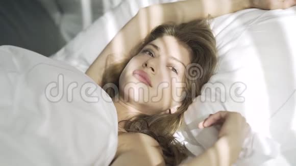 白色枕头上的年轻女人视频的预览图