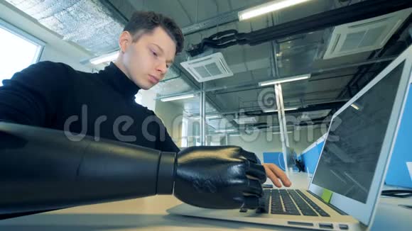 一个残疾的年轻人用他的笔记本电脑工作特写视频的预览图